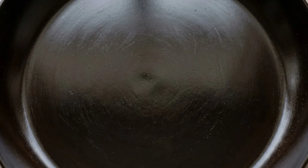 Close up of glossy well seasoned carbon steel skillet surface